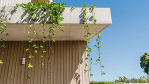 Un edificio con fachada de madera y estructura de hormigón.