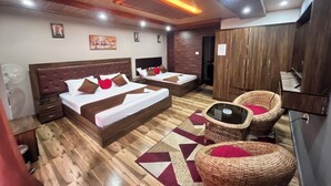 A hotel room with two beds, a TV, a wardrobe, and wicker chairs. - TRADITIONAL HOTEL AND RESTAURANT (Kurseong)