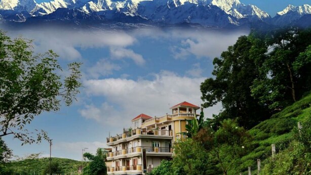 A two-story building with a red roof, located on a hillside with lush greenery. - TRADITIONAL HOTEL AND RESTAURANT (Kurseong)