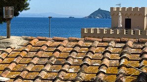 A tiled roof with a view of the sea and a building with a sign that reads "LEFFEFE". - La Perla del Cavo, just a stone's throw from the splendid seafront! (Cavo)