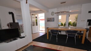 A modern living room with a flat-screen TV, a red rug, and a cityscape picture on a glass table. - Marvelous Escape Bol Island Villa With Pool (Bol)