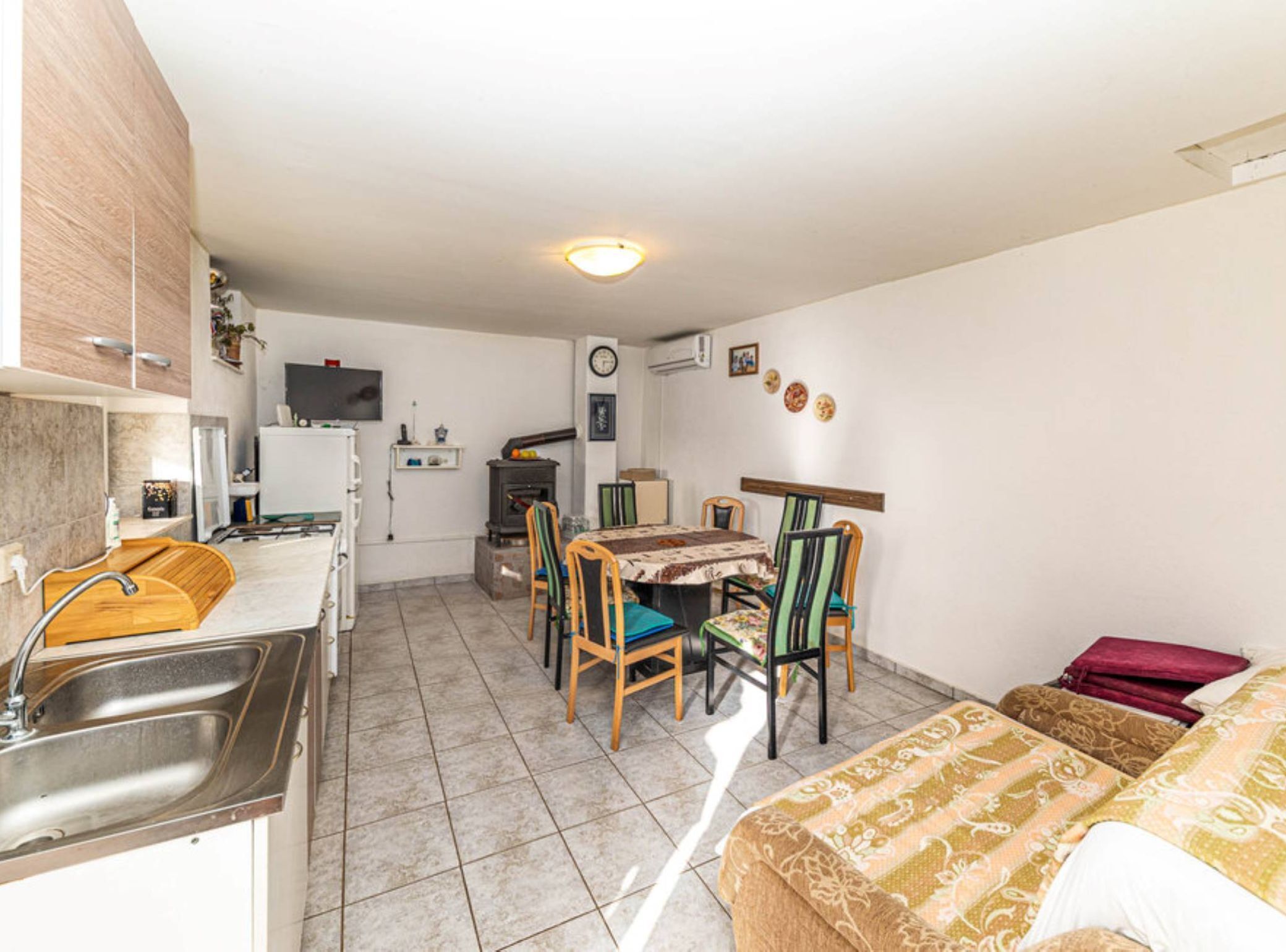 A compact room with a kitchenette, a dining area, and a bed.