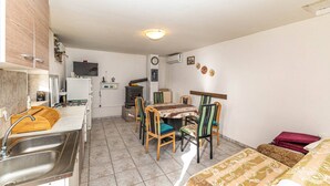 A compact room with a kitchenette, a dining area, and a bed.