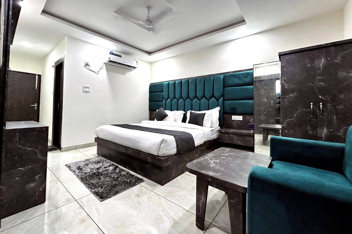Una habitación de hotel moderna con cama, escritorio, silla y armario.