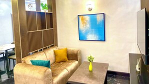 Una sala de estar moderna con un sofá, una mesa de centro, un cuadro colgado en la pared y una planta decorativa.
