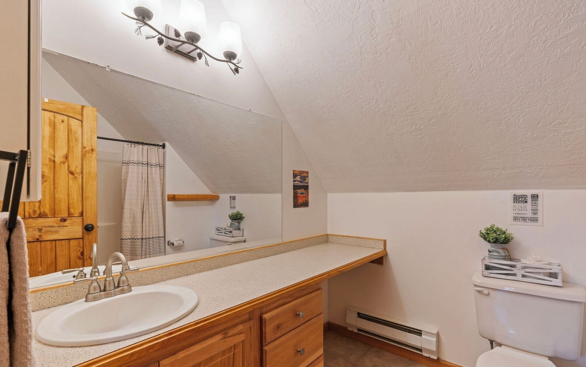 Une salle de bain équipée d’un lavabo, d’un meuble en bois, d’un porte-serviettes et de toilettes.