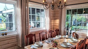 Een eetgedeelte met een houten tafel, gedekt voor vier personen, omringd door houten stoelen.