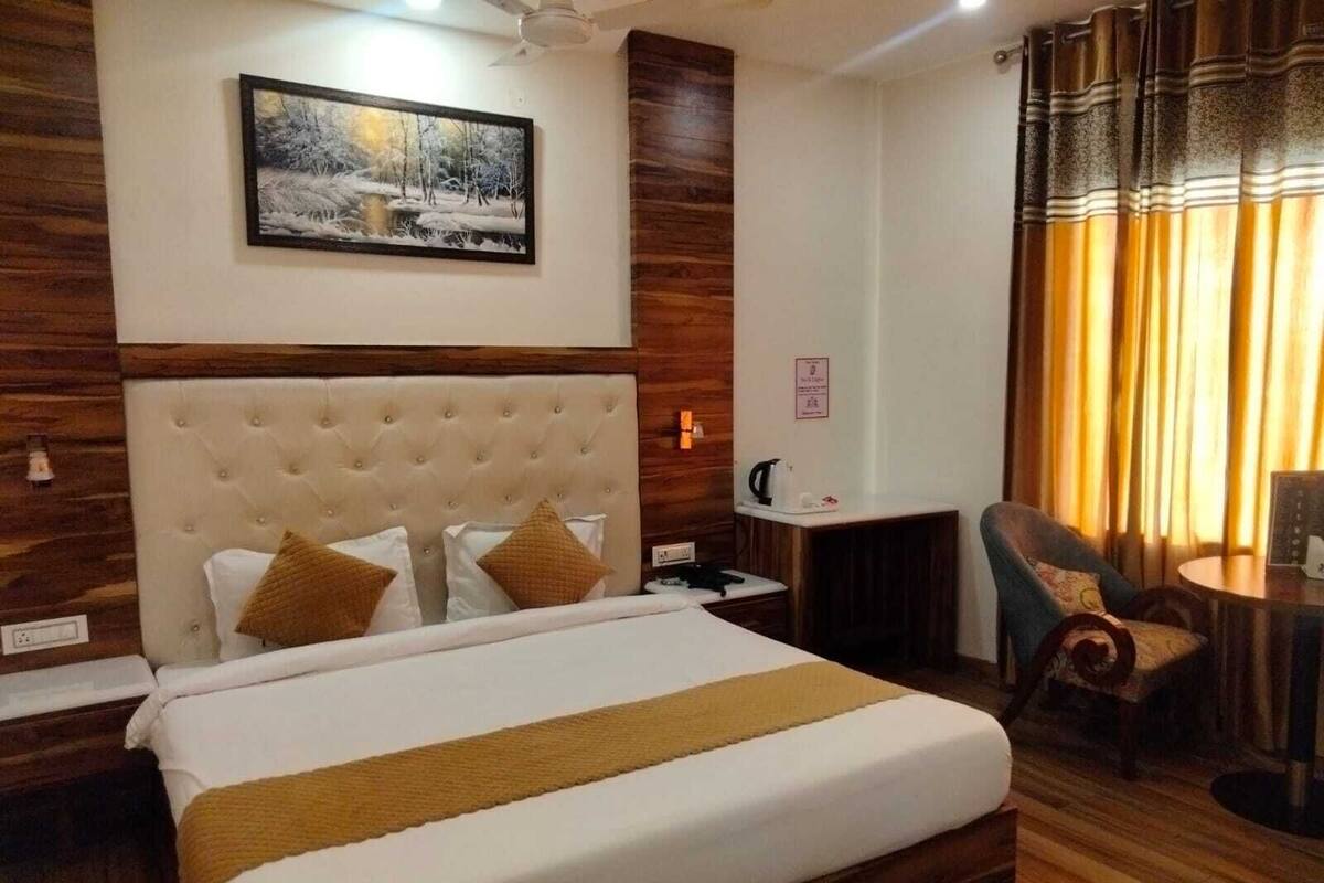 Ein Hotelzimmer mit einem großen Bett, einem Schreibtisch, einem Stuhl und einem Bild an der Wand.