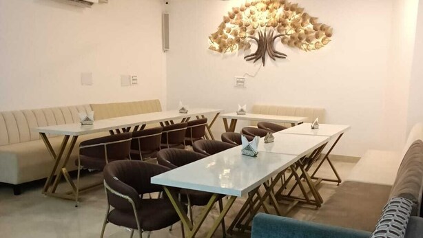 Uma zona de refeições moderna com uma mesa comprida, várias cadeiras e um elemento decorativo na parede.