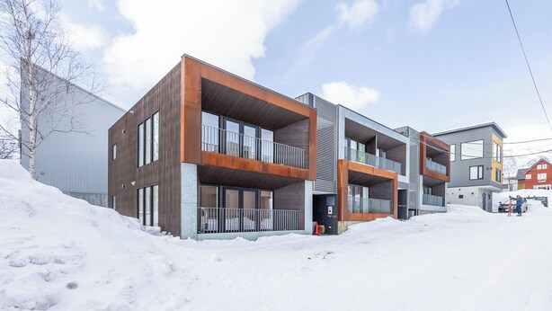 A modern multi-story building with large windows and balconies, surrounded by snow. - Hangetsu Niseko (Kutchan)