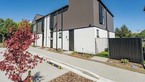 A modern building with a flat roof, large windows, and a gated entrance. - Central Haven (Wanaka)