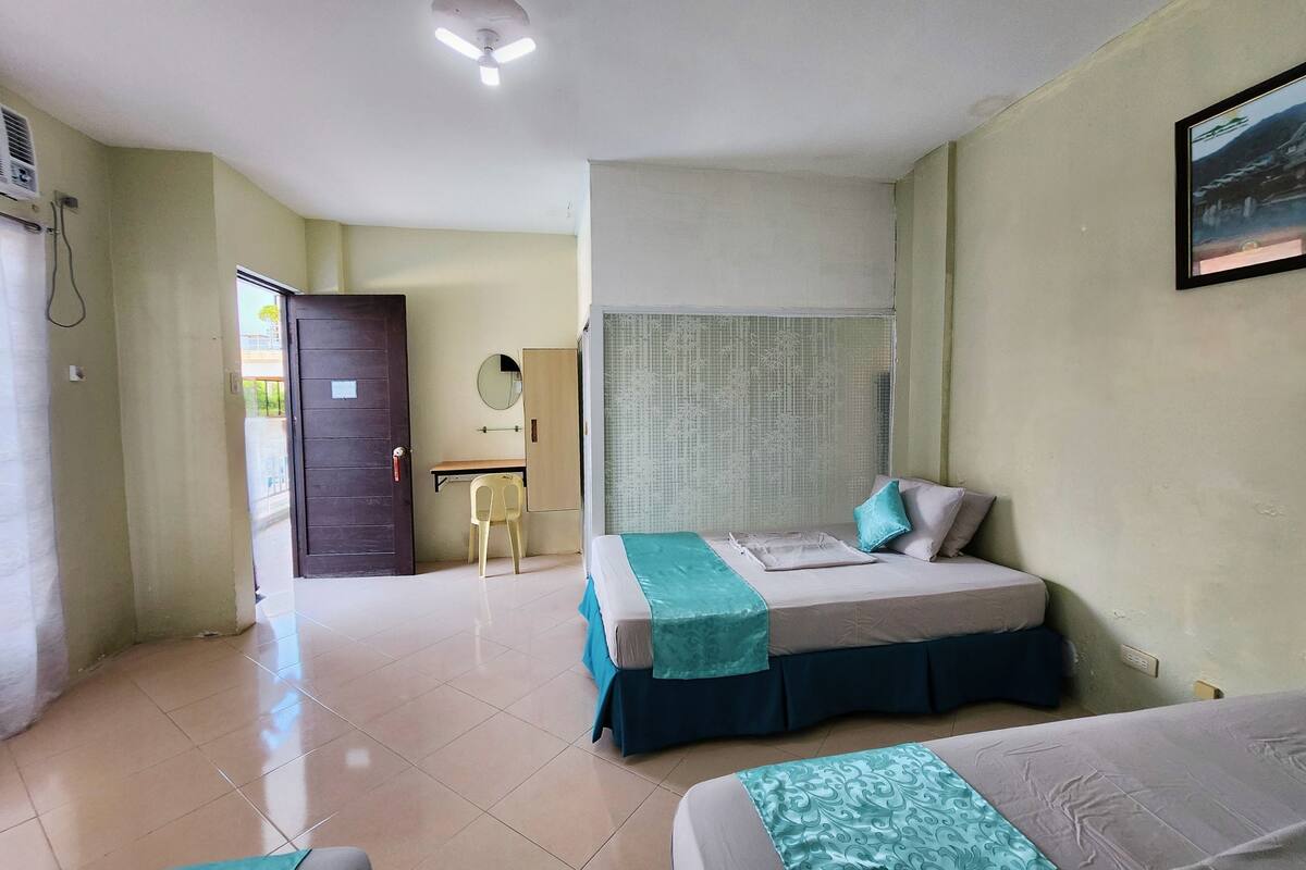 A bedroom with a bed, a desk, and a chair.