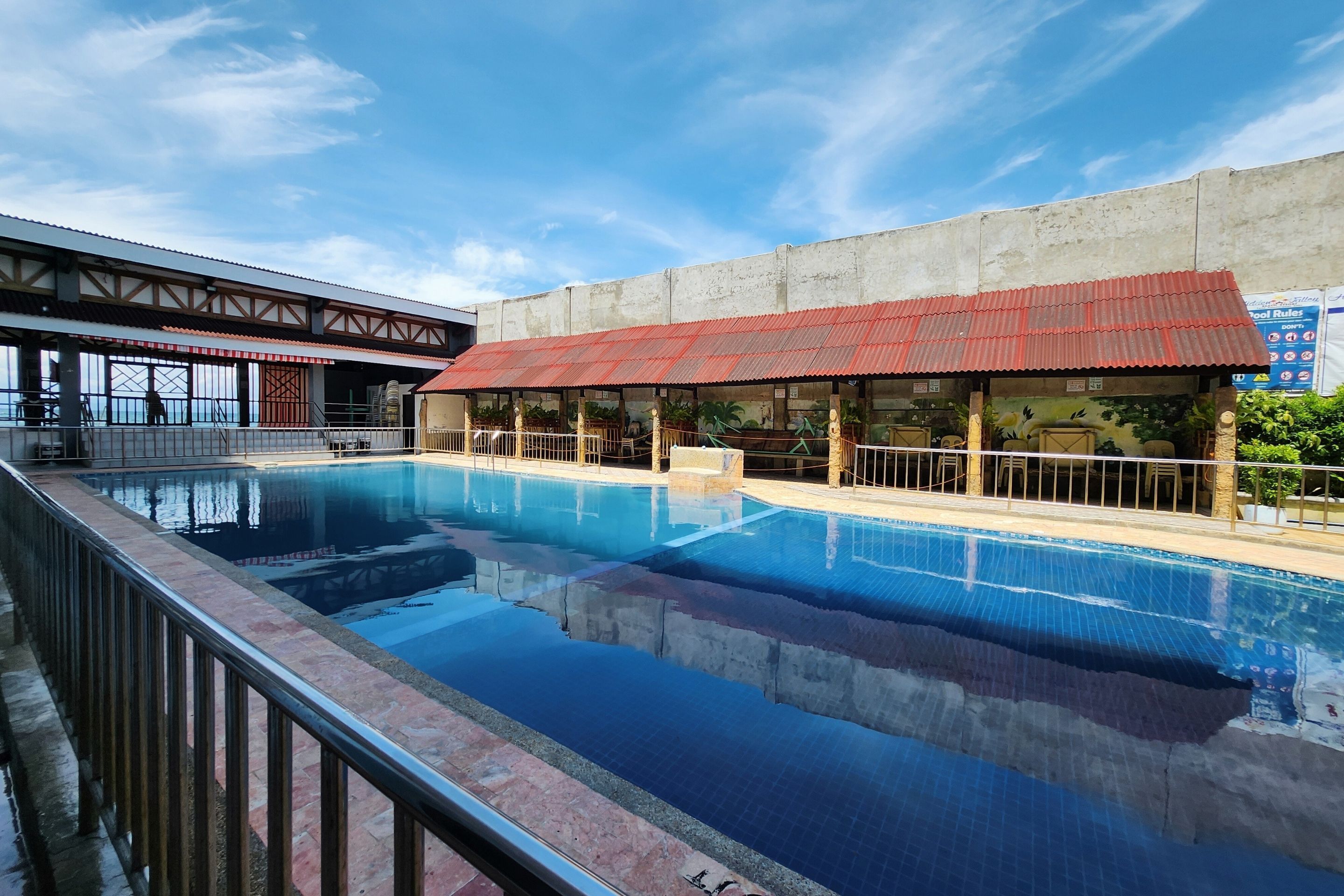 Une piscine avec, en arrière-plan, un bâtiment dont le toit est rouge.