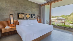 A modern bedroom with a large bed, wooden headboard, bedside tables, and artwork on the wall. - Villa Taman Famindo Canggu V-8 (Canggu)