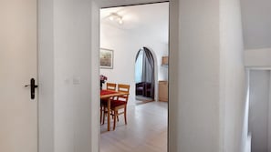 Vista interior de una habitación con comedor, cocina y sala de estar.