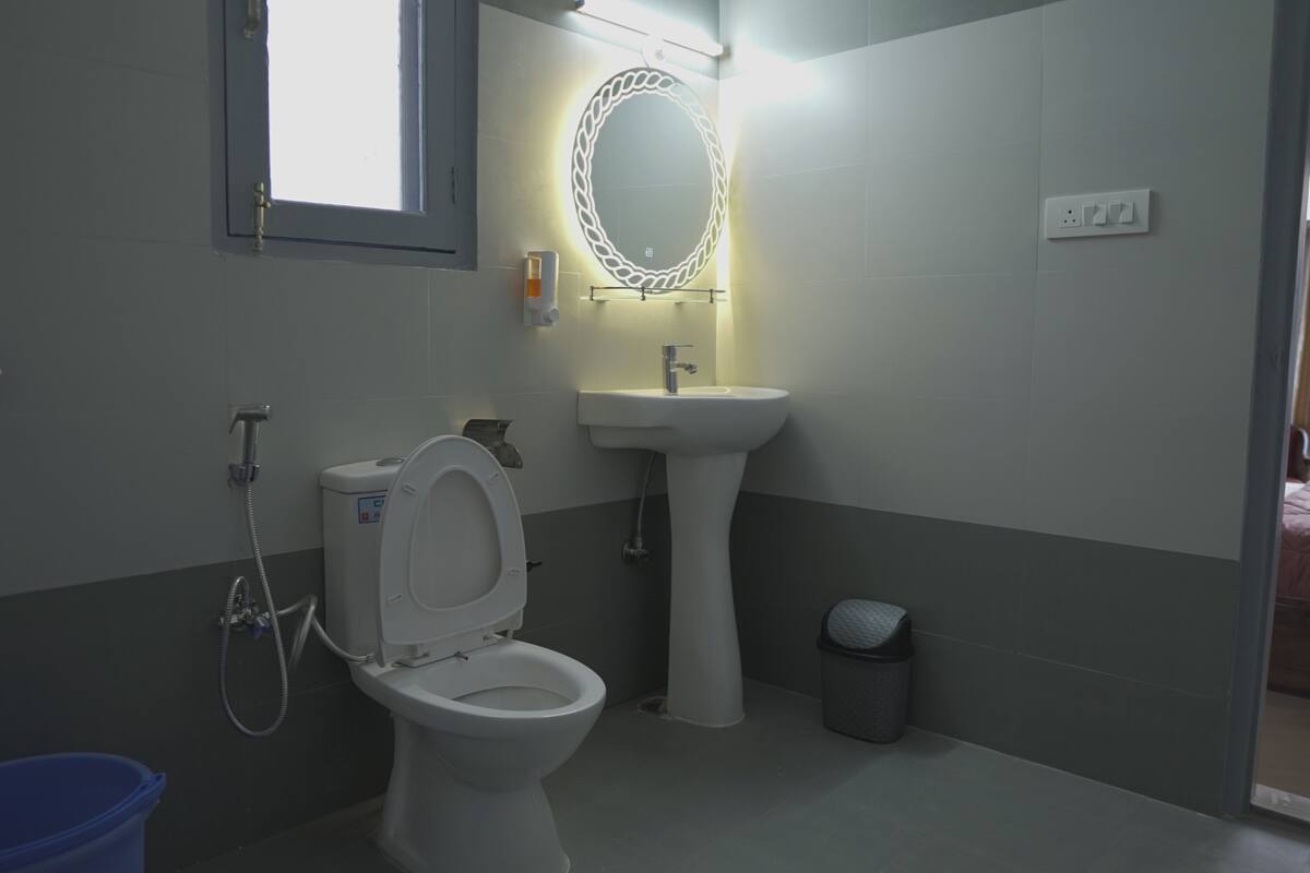 A bathroom with a toilet, sink, and mirror.