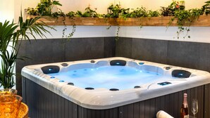 A hot tub with a wooden bench and a bottle of wine. - Tropical Wellness Suite Sauna, whirlpool, TV, BBQ (Büdesheim)