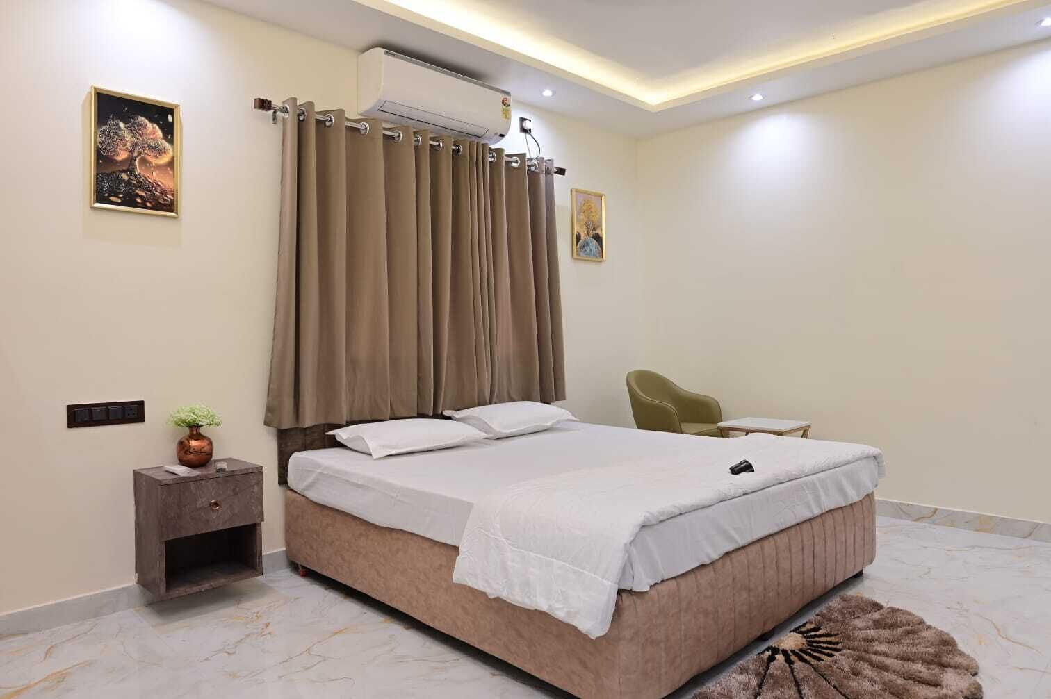 A modern bedroom with a large bed, a nightstand, a chair, and a small table.