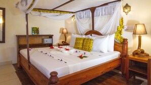 A four-poster bed with a canopy, bedside tables, and a wall-mounted lamp. - Mapenzi Suite Deluxe Suite Sea View with AC (Jambiani)