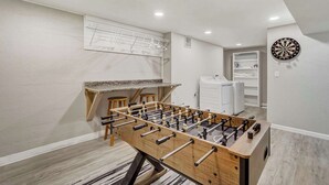 Une pièce équipée d’un baby-foot, d’un jeu de fléchettes et d’un étendoir à linge.