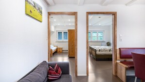 A modern room with a sofa, a wooden bench, and a bed with a wooden headboard.