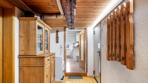 A hallway with wooden cabinets, a washing machine, and a coat rack.