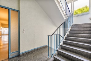 Un escalier avec des rampes bleues menant à l’étage supérieur.