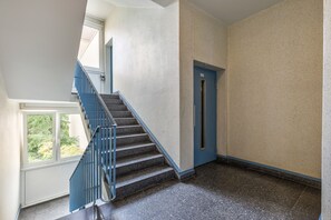 A staircase with blue railings leading to a door with a sign above it. - Apartment 'Am Schloss Charlottenburg' with Balcony and Wi-Fi (Berlin)