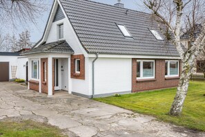 A house with a sloped roof, a small porch, and a brick exterior.