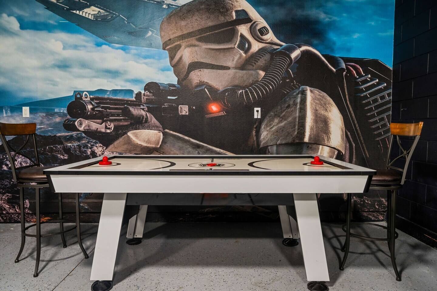 A foosball table with a Star Wars-themed mural in the background.