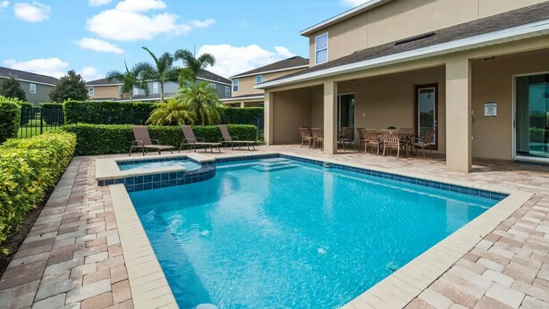 A swimming pool with lounge chairs and a patio area.
