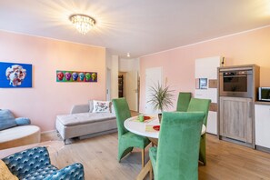 A modern living room with a dining area, a sofa, a coffee table, and a kitchen with a refrigerator. - Apartment 'Nr 7' with Wi-Fi (Schwelm)