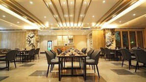Un comedor amplio con una mesa larga y múltiples sillas, una zona de bar y un muro decorativo con textura.