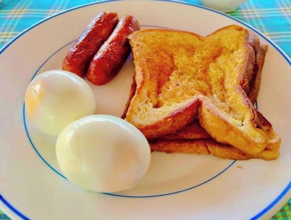 A plate with toast, sausages, and boiled eggs.