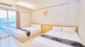 Ein Hotelzimmer mit zwei Betten, einem großen Fenster mit Blick und einer Schiebet ür zum Balkon.