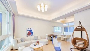 Ein modernes Wohnzimmer mit einer Couch, einem Couchtisch und einem Hängesessel.