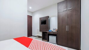 A hotel room with a bed, a desk, a TV, and a wardrobe. - Hotel O Marina Andalas (Makassar)