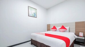 A hotel room with a neatly made bed, a nightstand, and a framed picture on the wall. - Hotel O Marina Andalas (Makassar)