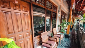A traditional wooden building with a tiled floor and a sign indicating room B2. - Tempo Doeloe Homestay (Kuta)
