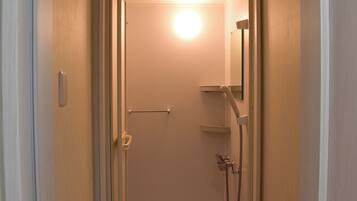 A bathroom with a shower, a towel rack, and a mirror.