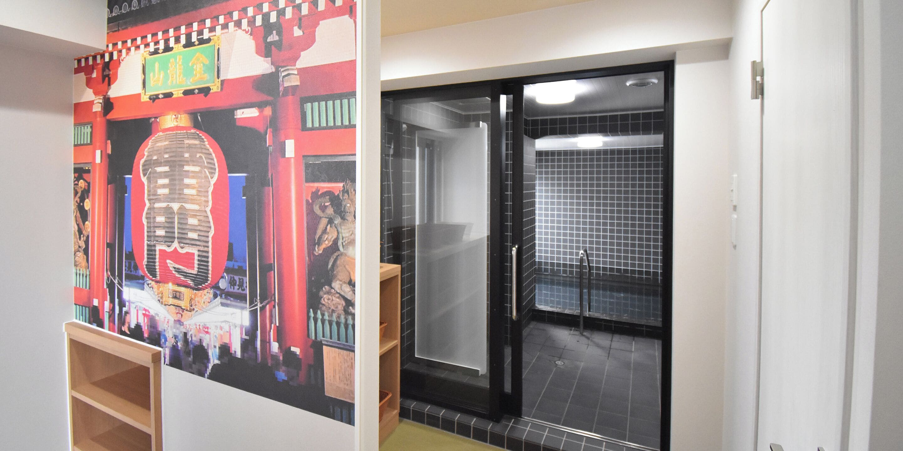A bathroom with a tiled floor, a shower area, and a door with a handle.