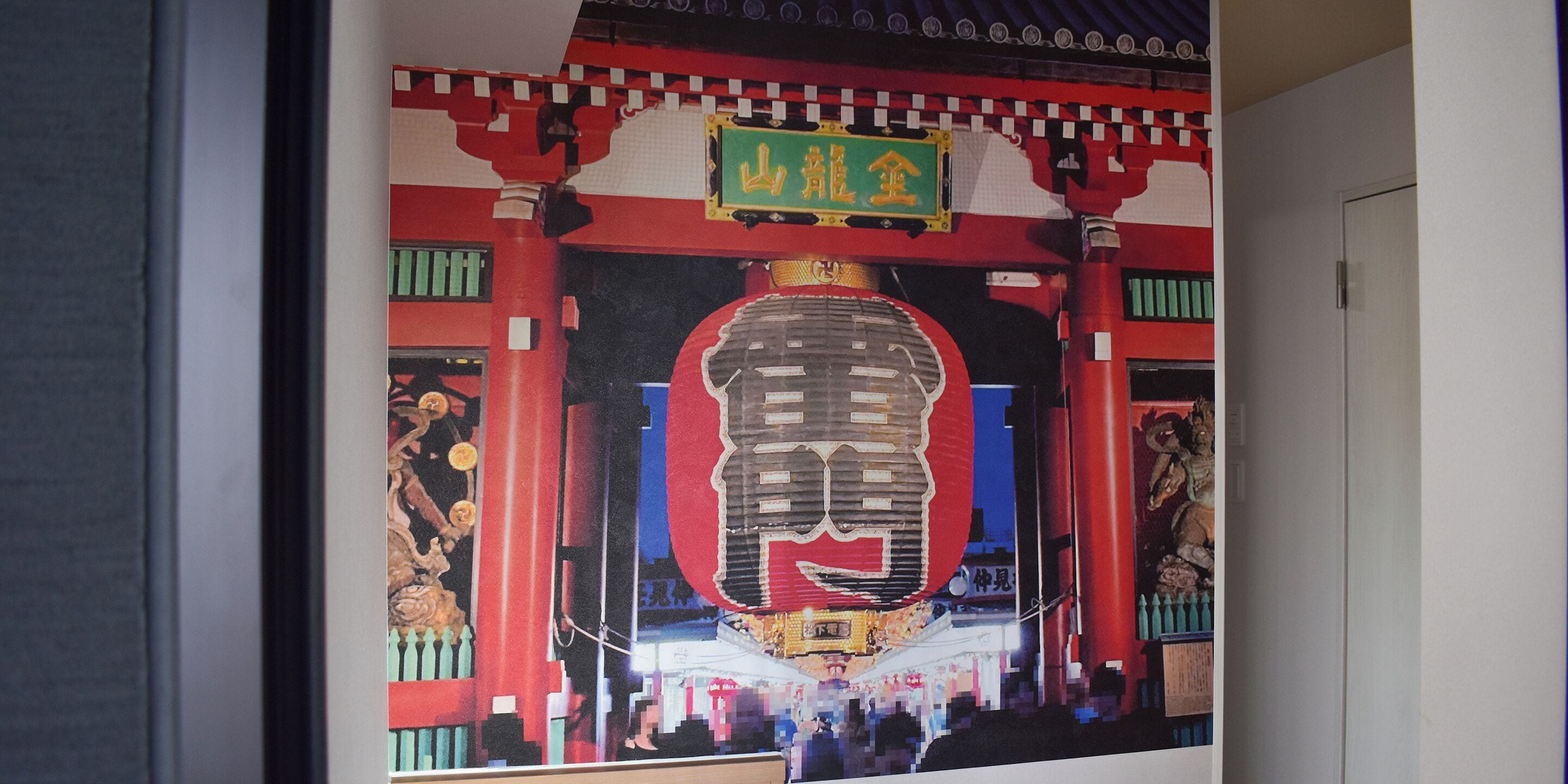 A traditional Japanese building with a large red torii gate and a golden sign above it.