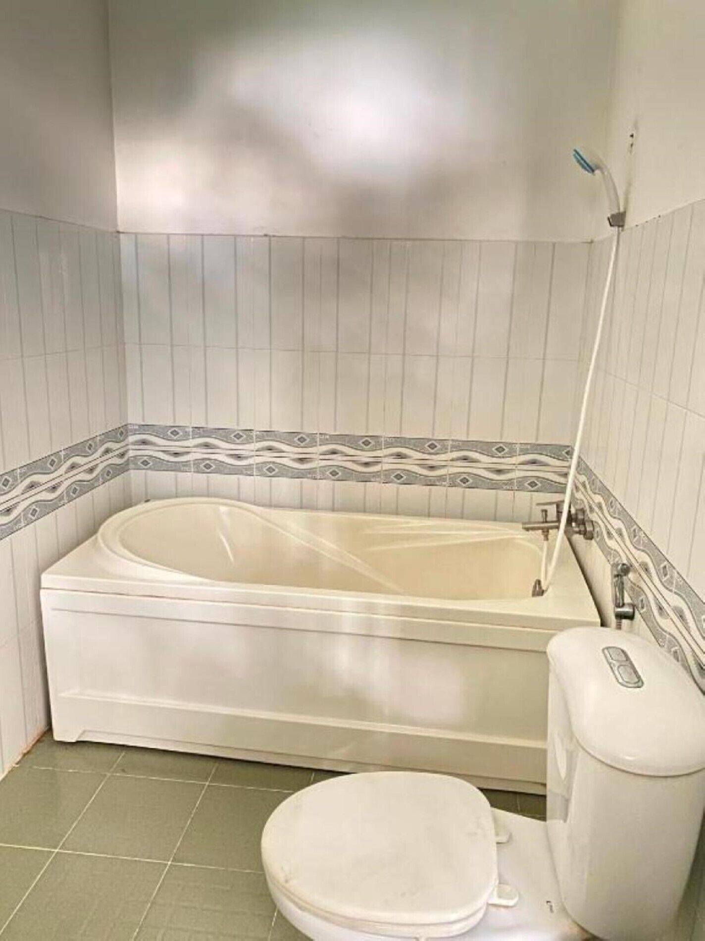 A bathroom with a bathtub, toilet, and a shower area.
