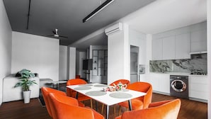 A modern kitchen with white cabinets, a built-in oven, and a washing machine.