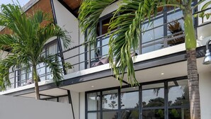 Une maison moderne dotée d’une piscine, d’une terrasse en bois et d’un espace salon extérieur.