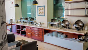 Una cocina moderna con un montaje tipo bufé, que incluye un mostrador con recipientes de comida y un espejo arriba.