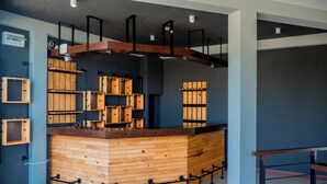 Un área de recepción con un mostrador de madera, varios armarios de madera y una barandilla de metal negro.