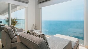 Un moderno salón con un amplio ventanal con vistas al mar.