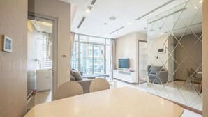 A modern meeting room with a large table, comfortable seating, a television, and a glass partition. - YoungC Apartment Landmark (Ho Chi Minh City)