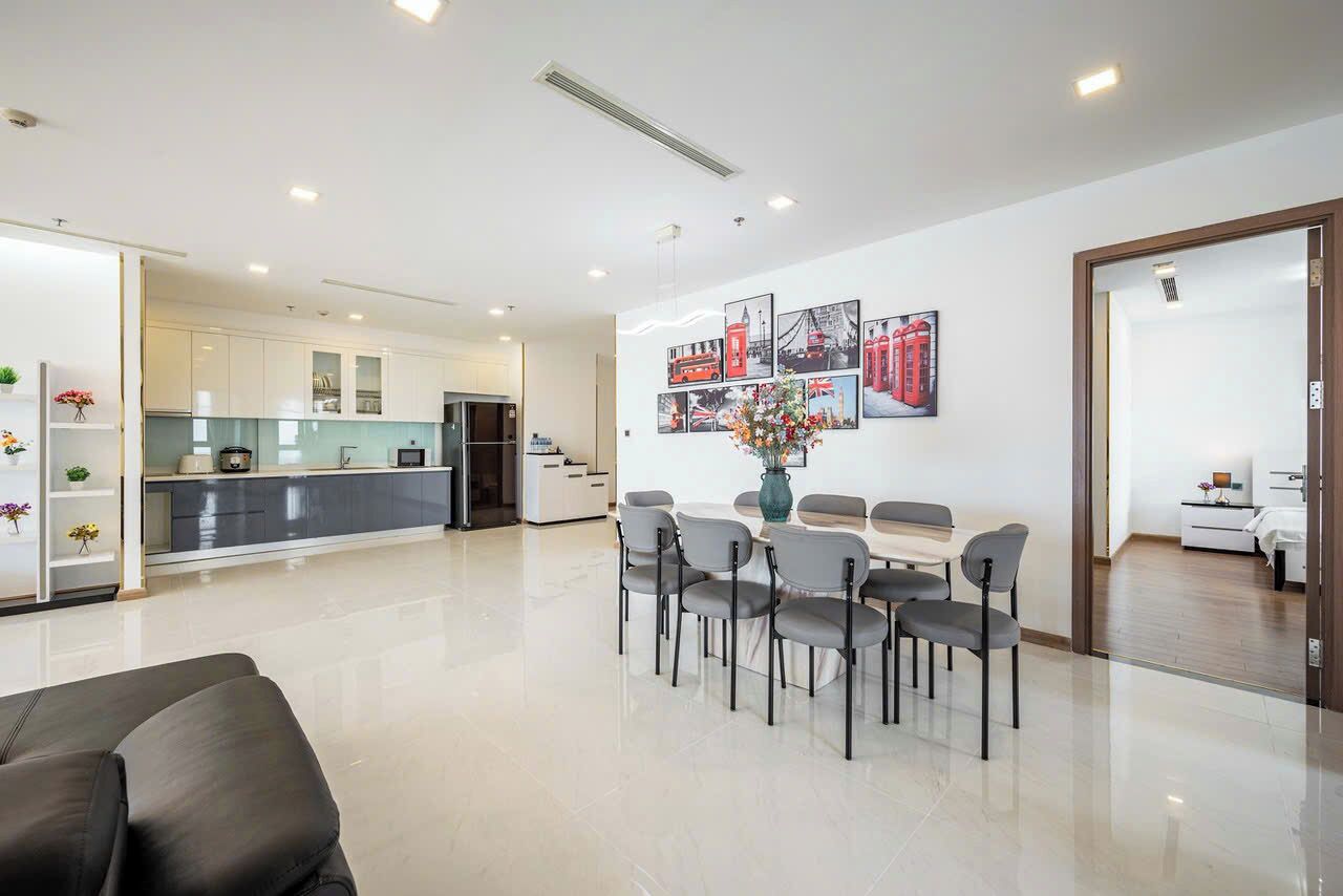 A modern hotel room with a dining area, a kitchen, and a living space.